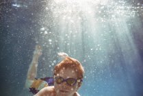 Close-up de um menino nadando debaixo d 'água em uma piscina — Fotografia de Stock