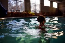 Девочка плавает в бассейне — стоковое фото