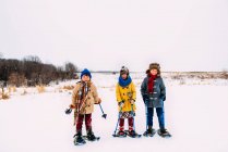 Três crianças prontas para uma caminhada em sapatos de neve, Estados Unidos — Fotografia de Stock