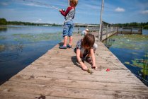 Três crianças pescando em uma doca no verão, Estados Unidos — Fotografia de Stock