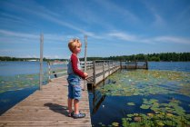 Boy standing on a dock fishing, United States — Stock Photo