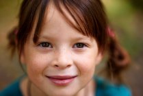 Portrait of a smiling girl with freckles standing outdoors, United States — Stock Photo