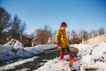 Девушка играет на луже тающего снега, США — стоковое фото