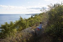 Boy sitting on rocks by Lake Superior, Estados Unidos — Fotografia de Stock
