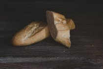 Tranches de pain français sur une table en bois — Photo de stock
