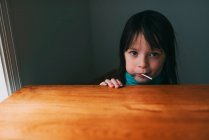 Retrato de uma menina comendo um chupa-chupa — Fotografia de Stock