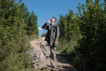 Wanderer steht auf einem Fußweg und telefoniert mit seinem Handy, Bosnien und Herzegowina — Stockfoto
