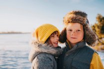 Portrait of a boy and girl standing by a lake, United States — Stock Photo