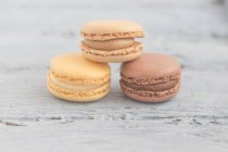 Three chocolate macaroons on a table — Stock Photo
