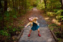 Chica de pie en una pasarela siendo tonto, Estados Unidos - foto de stock