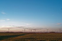 Барнакльские гуси летают над ветряными турбинами, Восточная Фризия, Нижняя Саксония, Германия — стоковое фото