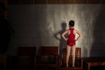 Fille dans un costume de natation faire des ombres contre un mur — Photo de stock