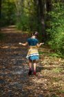 Chica caminando por un sendero a principios de otoño, Estados Unidos - foto de stock