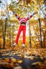 Niño saltando en un trampolín cubierto de hojas de otoño, Estados Unidos - foto de stock
