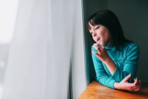 Retrato de una chica sonriente comiendo una piruleta - foto de stock