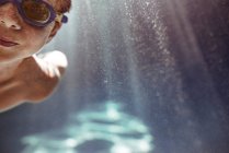 Close-up of a boy swimming underwater in a swimming pool — Stock Photo