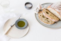 Pan de Ciabatta, aceite de oliva, sal y un vaso de agua - foto de stock