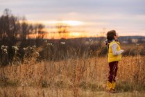 Boy standing in a field looking up at the sky, United States — Stock Photo