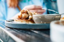 Frau isst Pfannkuchen mit Nüssen und Honig — Stockfoto