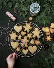 Donna mano su un rack di raffreddamento con biscotti di pan di zenzero di Natale — Foto stock