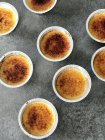 Silver foil ramekins with creme brulee, elevated view — Stock Photo