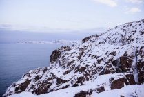 Людина взимку стоїть на скелі біля Баренцевого моря, в Мурманську (Росія). — стокове фото