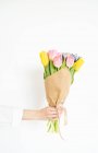 Женская рука с кучей разноцветных тюльпанов — стоковое фото