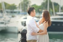 Портрет влюбленной пары, стоящей у пристани для яхт, Сингапур — стоковое фото