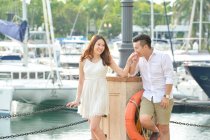 Портрет влюбленной пары, стоящей у пристани для яхт, Сингапур — стоковое фото
