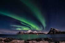 Luces boreales sobre montañas de Flakstad, Lofoten, Nordland, Noruega - foto de stock