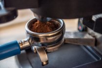 Close-up de uma pessoa anexando um portafilter a uma máquina de café expresso em um café — Fotografia de Stock
