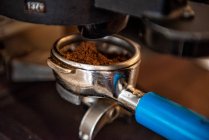 Close-up de uma pessoa anexando um portafilter a uma máquina de café expresso em um café — Fotografia de Stock
