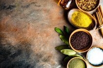 Various spices in bowls on wooden background — Stock Photo