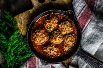 Baked potato with meat and spices in a cast iron skillet. selective focus. — Stock Photo