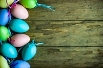 Uova di Pasqua e uova colorate su sfondo di legno — Foto stock