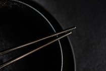 Chopsticks on black background — Stock Photo