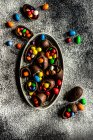 Colorful easter eggs in a bowl on a dark background. — Stock Photo