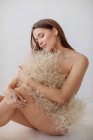 Nackte Frau schützt ihre Bescheidenheit mit einem Strauß getrockneter Pflanzen — Stockfoto