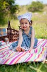 Ragazza sorridente seduta su una coperta da picnic nel parco, Bulgaria — Foto stock