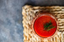 Sopa de tomate com pimenta vermelha e salsa em um fundo preto. — Fotografia de Stock