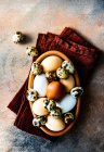 Bowl of eggs and quail eggs on a folded napkin on a table — Stock Photo