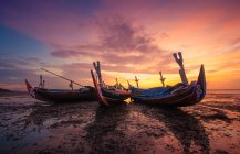 Trois bateaux traditionnels sur la plage au coucher du soleil, Tuban, Bali, Indonésie — Photo de stock