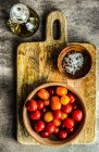 Fresh tomatoes in a bowl on a wooden background. top view. — Stock Photo