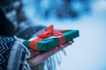 Крупним планом жінка тримає загорнутий різдвяний подарунок — стокове фото