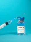Vacina Covid-19 e seringa numa mesa — Fotografia de Stock