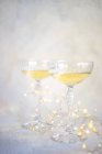 Zwei Gläser Champagner mit Lichterketten auf einem Tisch — Stockfoto