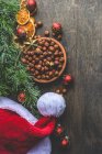 Різдвяна композиція з ялиновими гілками, шишками, сосною, корицею, горіхами, спеціями та ягодами на дерев'яному фоні — стокове фото