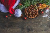 Christmas background with fir branches, cones, pine, nuts, red wine, cinnamon, anise, and — Stock Photo