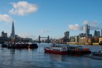 Boats sailing on River Thames, Tower bridge and city skyline, London, England, UK — Stock Photo