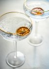 Вид сверху на два бокала шампанского с ломтиками сушеного апельсина — стоковое фото
